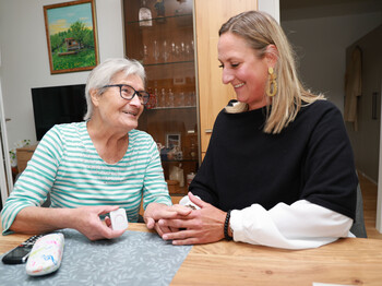 Ulla Pfister, Bewohnerin des Betreuten Wohnend Thalgau, mit Melanie Winkler, Caritas Salzburg, in ihrer Wohnung. Eine alte Frau mit Betreuerin