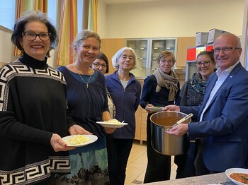 Personen in der Küche mit Essen auf Teller