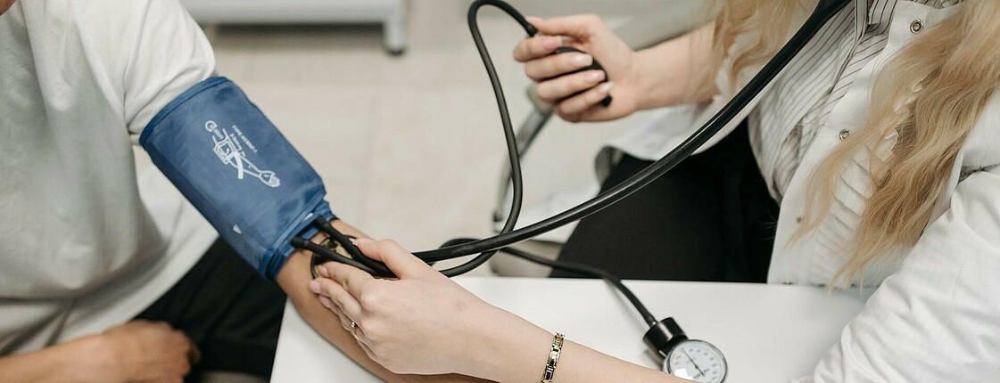 Ärztin beim Blutdruckmessen